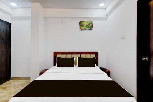 a bedroom with a bed in a white room at Super Collection O Hinjewadi Phase 1 Formerly Mars Venture in Hinjewadi