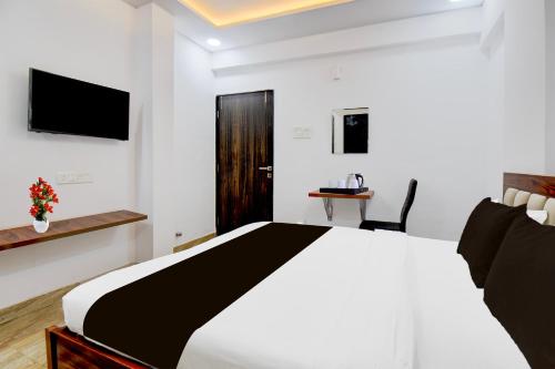a bedroom with a bed and a tv on the wall at Super Collection O Hinjewadi Phase 1 Formerly Mars Venture in Hinjewadi