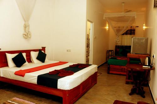a bedroom with a bed and a television in it at Blue Sky in Mirissa