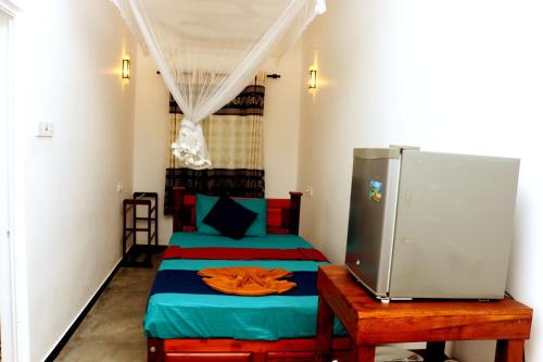 a small room with two beds and a table at Blue Sky in Mirissa