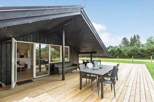 a patio with a table and chairs on a wooden deck at 8993-Orsted-Hejrevej-31 in Ørsted