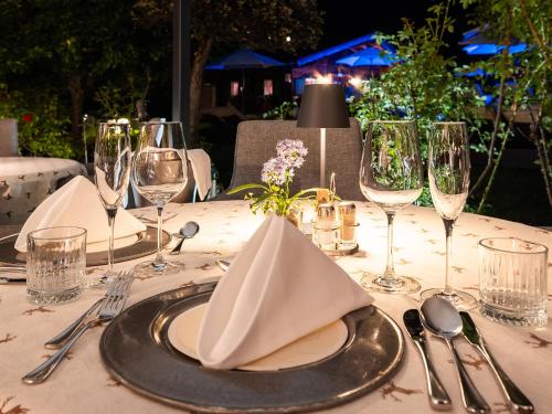 a table with glasses and a plate with a napkin at Alpenhotel Tirolerhof in Neustift im Stubaital
