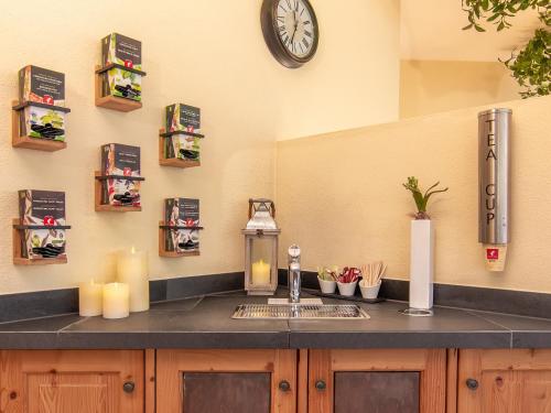 a kitchen counter with a sink and a clock on the wall at Alpenhotel Tirolerhof in Neustift im Stubaital