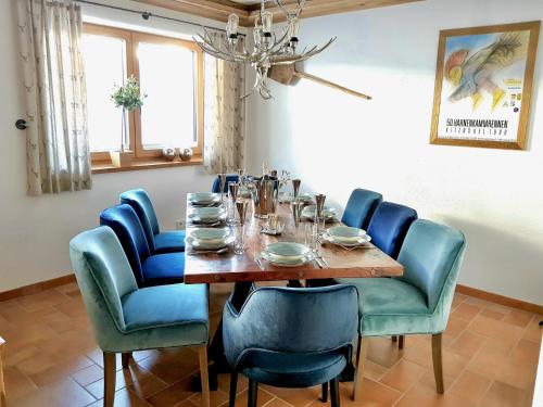 a dining room with a table and blue chairs at CHALET BELLE KAISER by Belle Stay in Going