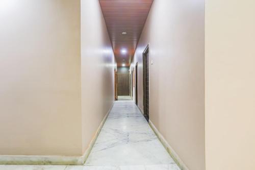 a corridor with white walls and marble floors and a ceiling at Super Collection O Jagannath Mandir Road Formerly Paradise Residency in Rāmnagar
