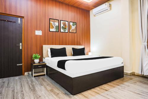 a bedroom with a large bed with an orange wall at Super Collection O Jagannath Mandir Road Formerly Paradise Residency in Rāmnagar