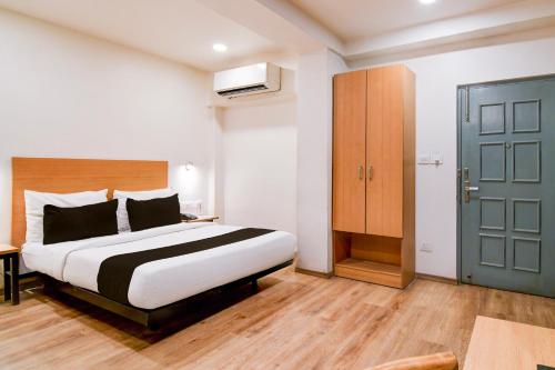 a bedroom with a bed and a blue door at Super Townhouse VIP Road Formerly The Sky in Kolkata