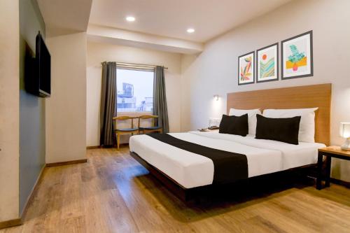 a hotel room with a large bed and a window at Super Townhouse VIP Road Formerly The Sky in Kolkata