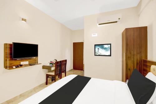 a bedroom with a bed and a tv on the wall at Super Collection O Virajpet City Centre formerly The Fort Mercara in Madikeri