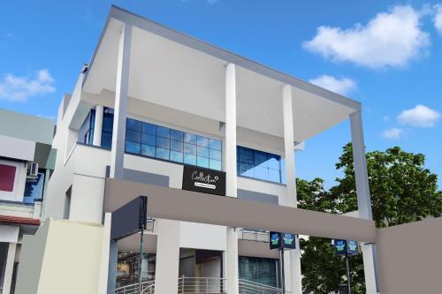 a white building with a sign on it at Super Collection O Virajpet City Centre formerly The Fort Mercara in Madikeri