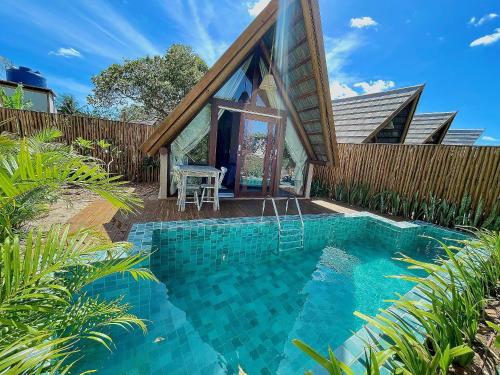 a swimming pool in the backyard of a house at Pousada Villa di Luna in São Miguel do Gostoso