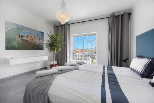 a bedroom with a large bed with a large window at Casa Surfer’s Sanctuary - Algarve in Vila do Bispo