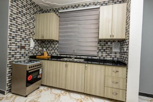 a kitchen with a sink and a stove at The Nest Kampala in Katale