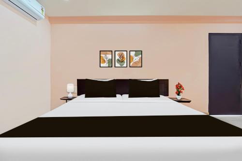 a bedroom with a large bed with black and white at Super Collection O Surathkal Beach in Suratakal