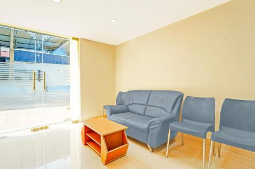 a waiting room with blue chairs and a table at Super Collection O Surathkal Beach in Suratakal