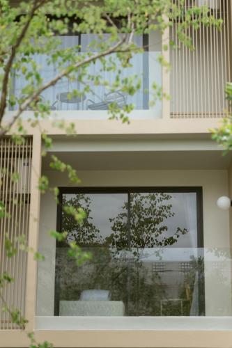 a window of a building with a reflection in it at PAAK Hotel Suvarnabhumi in Lat Krabang