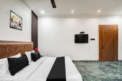 a bedroom with a bed and a tv on a wall at Super Collection O Ratan Lal Nagar in Kānpur