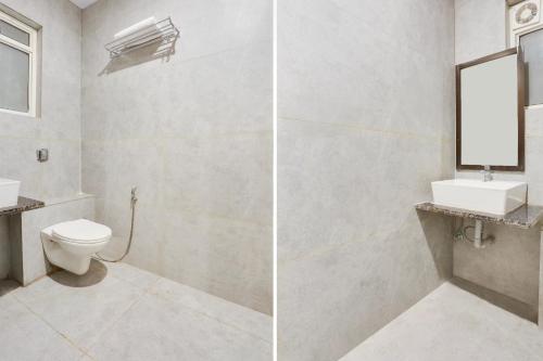 ein Badezimmer mit Toilette, Waschbecken und Spiegel in der Unterkunft Super Townhouse Jagatpura Downtown Formerly Hotel Buddhi in Jaipur