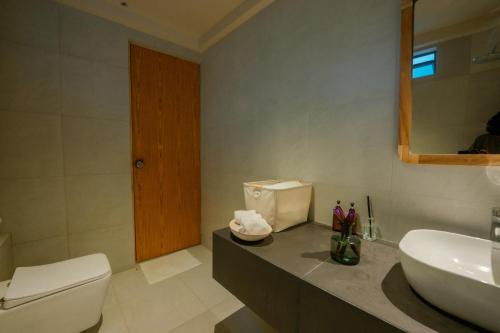 een badkamer met een wit toilet en een wastafel bij Rekawa Wellness Resort in Tangalle