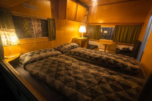 a bedroom with two beds and a lamp in it at Oldtimer Camp Main Spessart in Collenberg