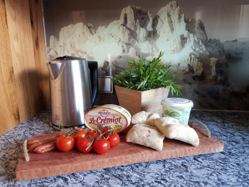 a cutting board with tomatoes and vegetables on a table at CHALET BELLE KAISER by Belle Stay in Going