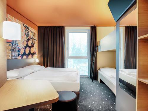 a hotel room with two beds and a window at B&B Hotel Bamberg in Bamberg