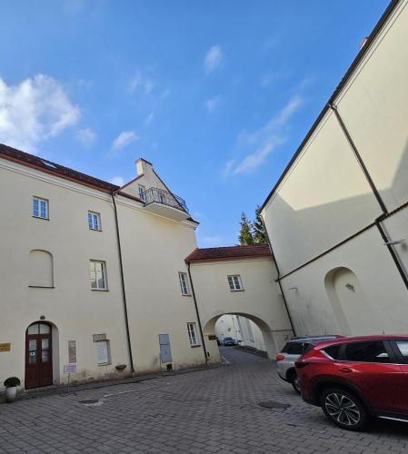 a group of buildings with cars parked in a parking lot at Domus Maria in Vilnius