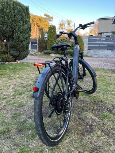 a bike parked on the grass in a yard at Rybacka 48 - Twoje miejsce wypoczynku, domki, studia, apartamenty, rowery, hulajnogi in Jantar