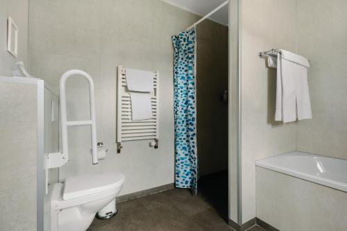 a white bathroom with a toilet and a shower at Hotel Kriunes in Reykjavík