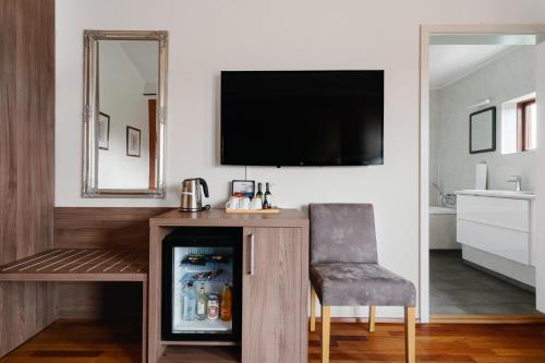 a room with a refrigerator and a chair and a television at Hotel Kriunes in Reykjavík