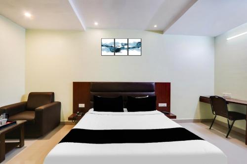 a bedroom with a large bed and a couch at Super Townhouse Gudivada Formerly Sistla in Gudivāda