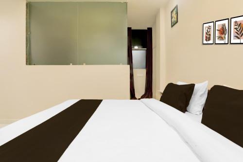 a bedroom with a white bed with a large mirror at Super Collection O Kakadeo Kanpur Formerly Hotel Avon in Kānpur