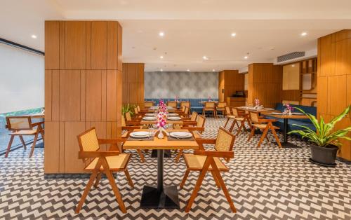 a dining room with wooden tables and chairs at Effotel by Sayaji Panaji, Goa in Panaji