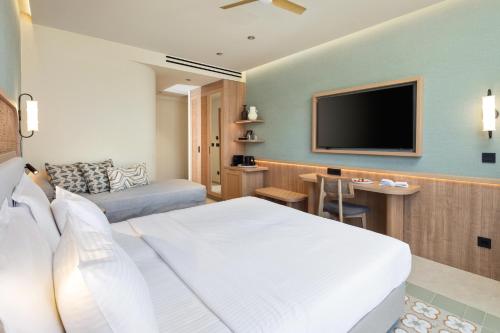 a hotel room with a bed and a flat screen tv at SENTIDO Apollo Palace in Mesongi