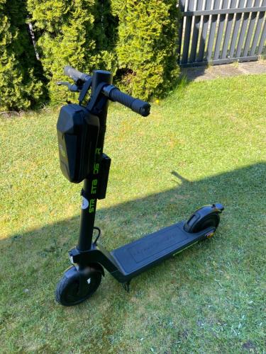 a scooter parked on the grass in a yard at Rybacka 48 - Twoje miejsce wypoczynku, domki, studia, apartamenty, rowery, hulajnogi in Jantar