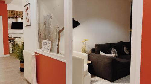 een woonkamer met een bank en een stoel bij La maison d'Angelique - Coliving Hotel - Gare de Niort in Niort