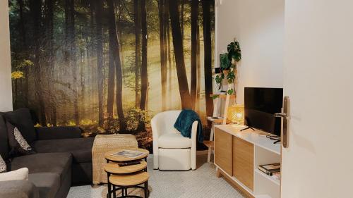 een woonkamer met een bank en een tv bij La maison d'Angelique - Coliving Hotel - Gare de Niort in Niort
