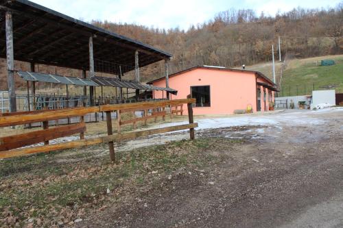a barn with a fence in front of a building at Agriturismo Natura e Gusto fattoria didattica in Cascia