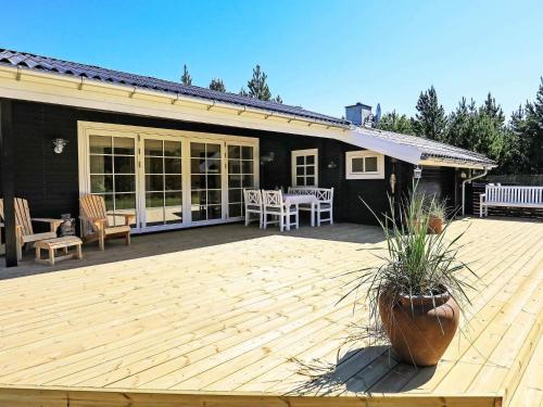 una terraza de madera con mesa y sillas en una casa en Cozy Beach House - By Traum Ferienwohnungen, en Jerup