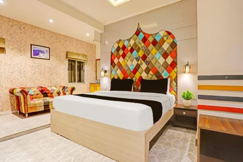 a bedroom with a large bed and a couch at Super Townhouse Cantonment Varanasi Formerly Sarin Inn in Varanasi