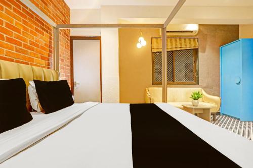 a large bed in a room with a brick wall at Super Townhouse Cantonment Varanasi Formerly Sarin Inn in Varanasi