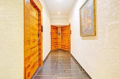 a hallway with a wooden door and a tile floor at Super Townhouse Cantonment Varanasi Formerly Sarin Inn in Varanasi
