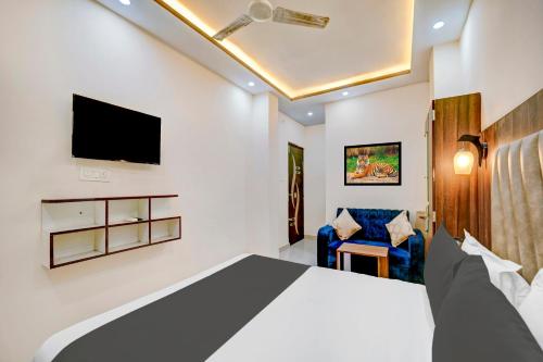 a bedroom with a bed and a tv and a chair at Super Townhouse Anisabad Near Mahavir Sansthan in Khagaul