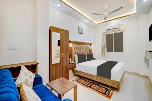 a bedroom with a bed and a blue couch at Super Townhouse Anisabad Near Mahavir Sansthan in Khagaul