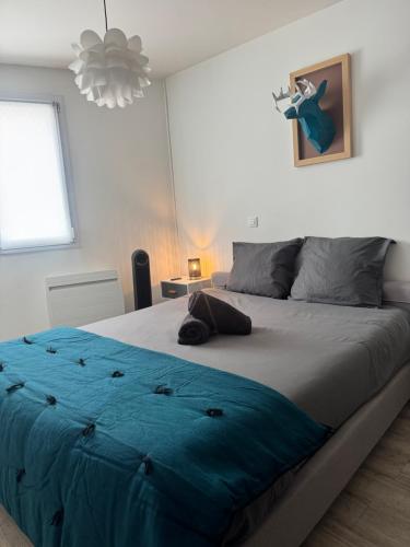 sypialnia z dużym łóżkiem i niebieskim kocem w obiekcie Appartement cosy face à la basilique Saint Remi w mieście Reims