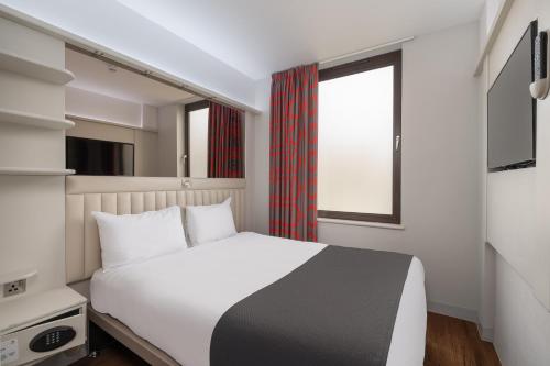 a bedroom with a white bed and a window at Point A London Liverpool Street in London