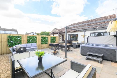 a patio with a table and chairs and a grill at The Cosy Tap - At The Retreat in Knottingly