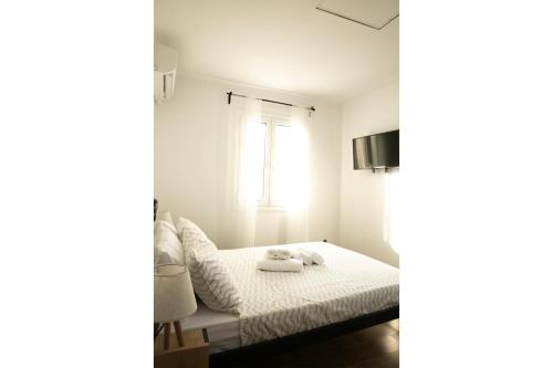 a bedroom with a bed and a window at Waves Of Eros in Paralía