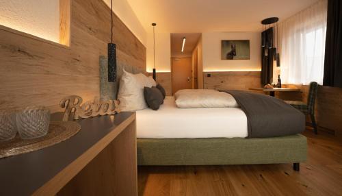 a bedroom with a bed in a room with a table at Aparthotel Fernblick in Fiss