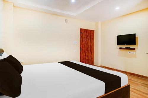 a bedroom with a bed and a tv on the wall at Super Collection O Last Gate Near Dispur Law College Formerly RR hotels in Dispur